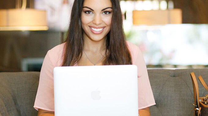 Woman Sitting behind Laptop Smiling